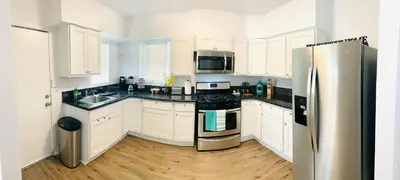 a kitchen with white cabinets and a stainless steel refrigerator at Cozy Home Away From Home in Mojave