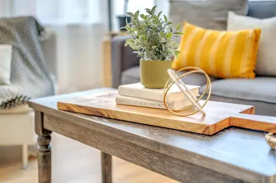 a coffee table with a book and glasses on it at Centrally Located Charming LA Home with Food Scenes in Monterey Park