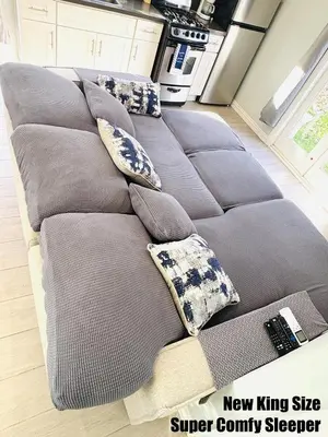 a gray couch with pillows on it in a kitchen at Cozy Serene Studio Backhouse w parking near it all in South Gate
