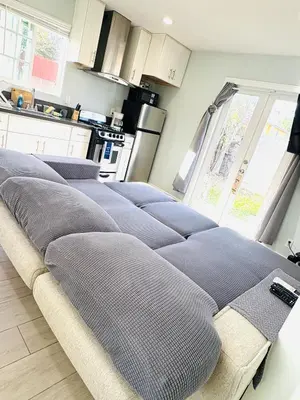 a living room with a row of pillows on a couch at Cozy Serene Studio Backhouse w parking near it all in South Gate