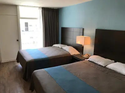 a hotel room with two beds and a window at Inn Of Long Beach in Long Beach