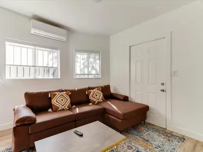 a living room with a brown couch and a table at Modern 3 Bedroom Apartment in San Fernando in San Fernando