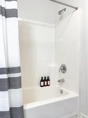 a white bathroom with a tub and a shower at 2BD 2BTH Apartment in Marina Del Rey - Free Parking - 20 mins to LAX in Los Angeles