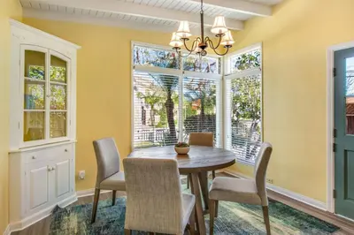 a dining room with a table and chairs and windows at Beach Breeze Bungalow 1 Miles To Beach Cozy in Redondo Beach