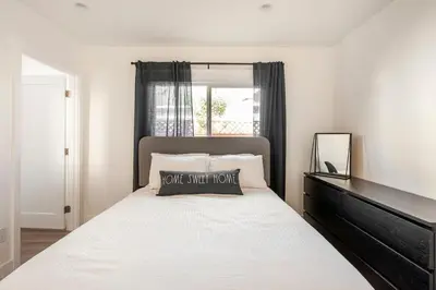 a bedroom with a bed with a black headboard and a mirror at Stylish Gated Retreat in East Hollywood with Parking in Los Angeles