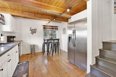 a kitchen with a stainless steel refrigerator and wooden ceilings at Village Relaxation at Camp Conklin Big Bear - Hot Tub in Big Bear Lake