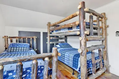 a bedroom with two bunk beds and a ladder at Village Relaxation at Camp Conklin Big Bear - Hot Tub in Big Bear Lake
