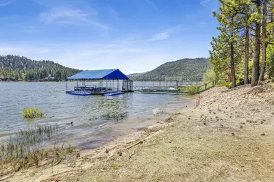 a boat dock with a blue tent on a lake at Inspiration Point Retreat by Big Bear Vacations in Big Bear Lake
