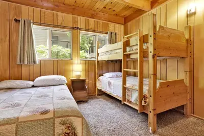 a bedroom with two bunk beds and a window at Inspiration Point Retreat by Big Bear Vacations in Big Bear Lake