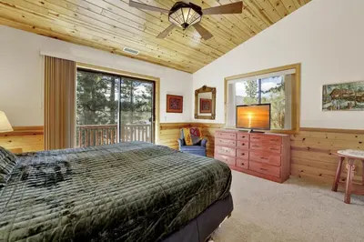 a bedroom with a bed and a flat screen tv at Eagle Point Lake House by Big Bear Vacations in Big Bear Lake