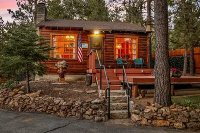 a log cabin with an american flag in front of it at The Nest on Towne Trail by Big Bear Vacations in Big Bear Lake