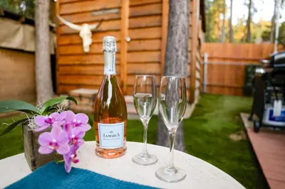 a bottle of wine and two wine glasses on a table at The Nest on Towne Trail by Big Bear Vacations in Big Bear Lake
