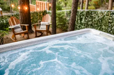 a jacuzzi tub with two chairs and a table at The Nest on Towne Trail by Big Bear Vacations in Big Bear Lake