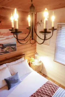 a bedroom with a bed with a chandelier at The Nest on Towne Trail by Big Bear Vacations in Big Bear Lake