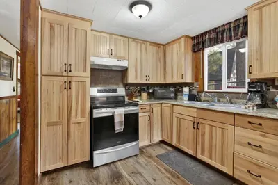 a kitchen with wooden cabinets and a stove top oven at Green Squirrel Chateau by Big Bear Vacations in Big Bear Lake