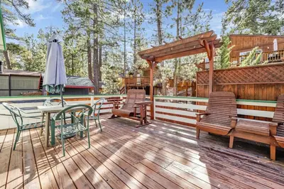a deck with chairs and a table and an umbrella at Green Squirrel Chateau by Big Bear Vacations in Big Bear Lake