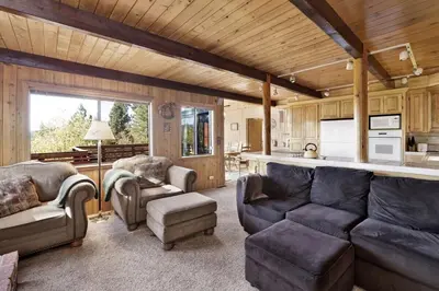a living room with a couch and chairs and a kitchen at Mountain Hideaway on Maryland by Big Bear Vacations in Big Bear Lake