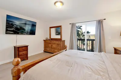 a bedroom with a bed and a mirror and a window at Temple Bear Chalet by Big Bear Vacations in Big Bear Lake