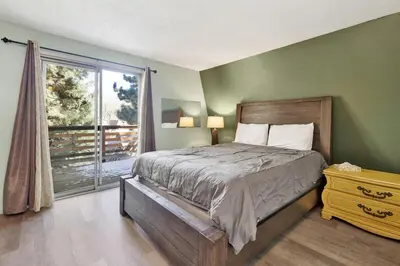a bedroom with a bed and a large window at Aeroplane Gambrel Chalet- Adorable Airport Retreat Cottage in Big Bear City