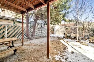 a porch with a wooden bench and a fence at Aeroplane Gambrel Chalet- Adorable Airport Retreat Cottage in Big Bear City
