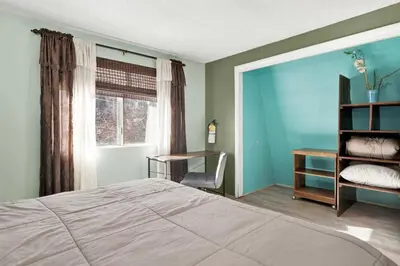 a bedroom with a bed and a desk and a window at Aeroplane Gambrel Chalet- Adorable Airport Retreat Cottage in Big Bear City