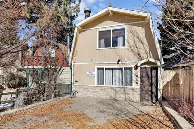 a brown house with a gate and a fence at Aeroplane Gambrel Chalet- Adorable Airport Retreat Cottage in Big Bear City