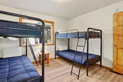 two bunk beds in a room with a window at Oriole House- Walk to Lake Chalet w/ Hot Tub in Big Bear Lake