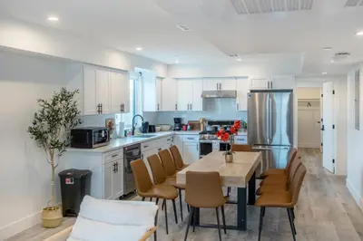 a kitchen with a wooden table and chairs at Urban Oasis in the Heart of LA Near USC & Major Attractions in Los Angeles