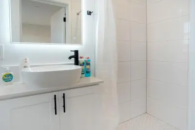 a white bathroom with a sink and a shower at Stylish & Cozy Retreat Near USC & Downtown LA in Los Angeles
