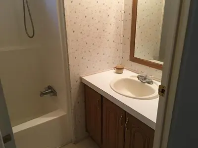 a bathroom with a sink and a mirror and a tub at Epic View Hot tub National forest in Wofford Heights