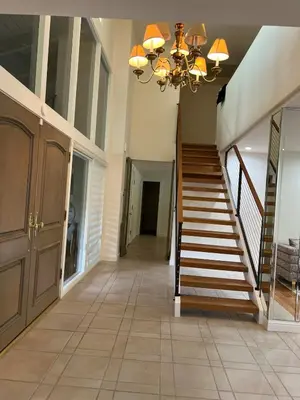 a hallway with a staircase in a home with a chandelier at Porter Paradise in Deer Lake Highlands