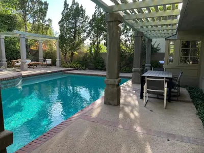 a swimming pool with a table and a pergola at Porter Paradise in Deer Lake Highlands