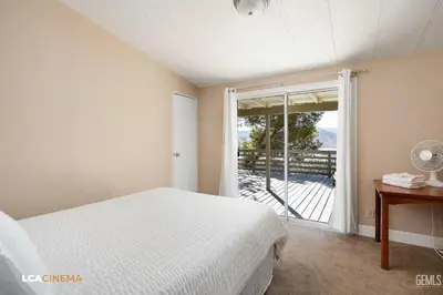 a bedroom with a bed and a large window at Scenic Lake House & Dog Friendly in Wofford Heights