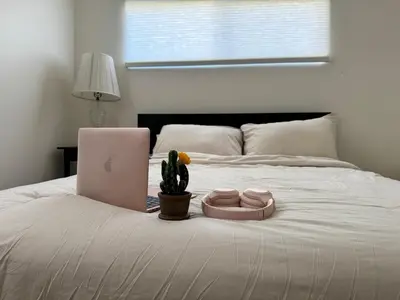 a bed with a laptop and a cactus on it at gateway to the ocean in Hawthorne