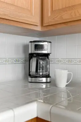 a coffee maker on a counter next to a coffee cup at gateway to the ocean in Hawthorne