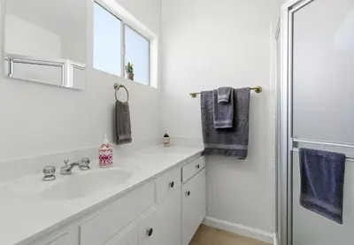 a white bathroom with a sink and a mirror at gateway to the ocean in Hawthorne