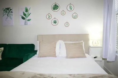 a bedroom with a white bed and a green couch at Studio Luxury Marina del Rey with parking gym pool in Los Angeles
