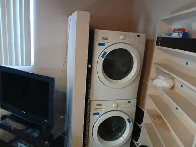 a washing machine and a tv in a room at Private room furnished Cypress in Lomita
