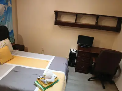 a bedroom with a bed and a desk and a chair at Handcraft Cabin LAX Port of LA 20 min away in Lomita