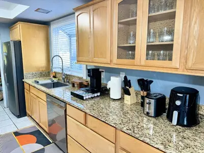 a kitchen with wooden cabinets and a counter top at Modern & Spacious Family and Friend 4B3B House in Moreno Valley