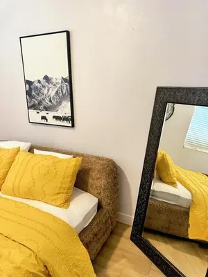 a mirror next to a bed with a yellow blanket at Modern & Spacious Family and Friend 4B3B House in Moreno Valley