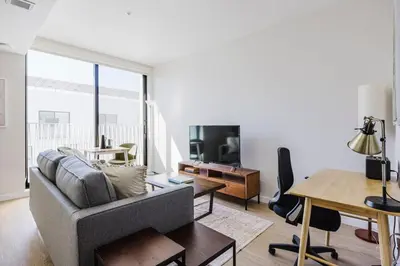 a living room with a couch and a tv and a table at Blueground Downtown elevator nr parks LAX-1235 in Los Angeles