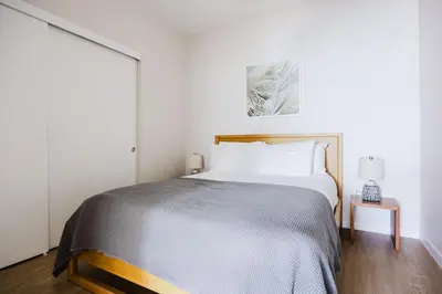 a bedroom with a large bed with white walls at Blueground Downtown elevator nr parks LAX-1235 in Los Angeles