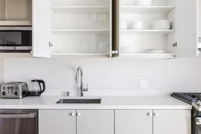a kitchen with white cabinets and a sink at Blueground Downtown elevator nr parks LAX-1235 in Los Angeles