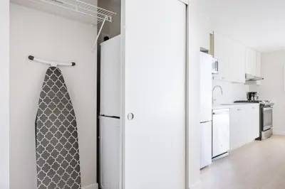 a kitchen with white walls and a door with a tie at Blueground Downtown elevator nr parks LAX-1235 in Los Angeles