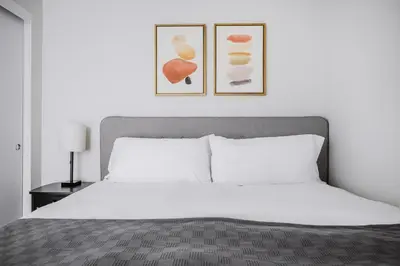 a bedroom with a white bed with two pictures on the wall at Blueground Downtown elevator nr The Broad LAX-1236 in Los Angeles