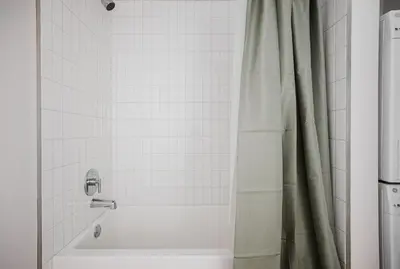 a bathroom with a tub and a shower curtain at Blueground Downtown elevator nr The Broad LAX-1236 in Los Angeles
