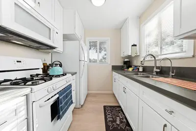 a kitchen with white cabinets and a stove top oven at Comfy 2 BR House near LAX, SOFI and Intuit Dome! in Inglewood