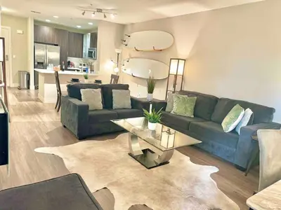 a living room with a couch and a table at Surfs up! Cozy 1 Bedroom Condo with Fountain View in Los Angeles