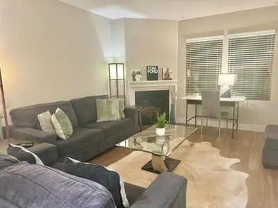a living room with a couch and a table at Surfs up! Cozy 1 Bedroom Condo with Fountain View in Los Angeles